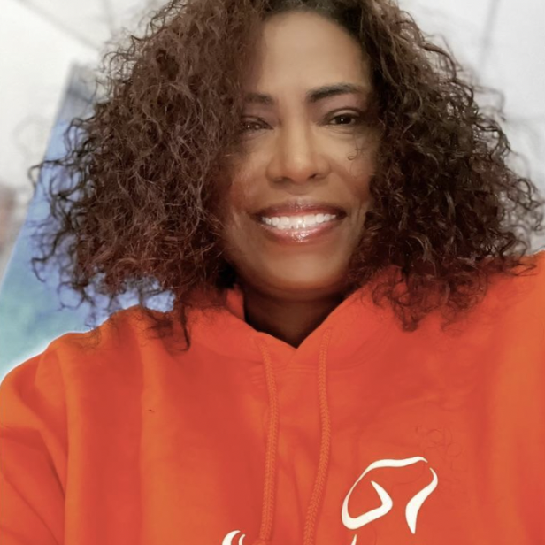 Image of Board Member, Regina Y. Hicks, wearing red and smiling.
